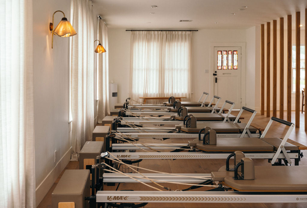 Homebody Studios Austin, with softly lit windows, warm wood details and Pilates reformers