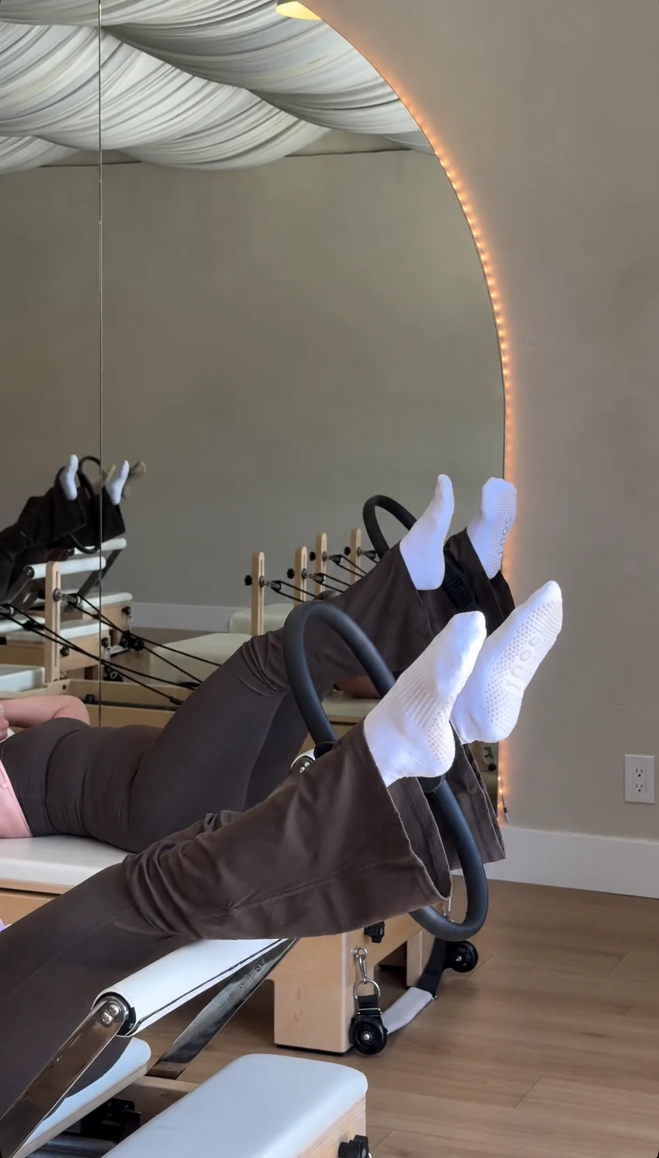 Pilates participants using reformers and wearing grip socks